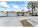 Charming single-story home showcasing a manicured front yard, brick driveway, and a two-car garage at 5 Marina Ter, Treasure Island, FL 33706