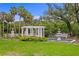 Picturesque backyard featuring a pergola, fountain, lush greenery, and mature palm trees at 5002 S Shore Crest Cir, Tampa, FL 33609