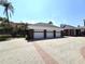 Spacious 3-car garage with brick-paved driveway, lush landscaping, and adjacent to a grand brick estate at 5002 S Shore Crest Cir, Tampa, FL 33609