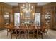 Dining room featuring wood paneled walls, a crystal chandelier, and a formal dining table set for 10 at 5002 S Shore Crest Cir, Tampa, FL 33609
