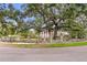 Distinguished brick home behind stone wall, iron gate, and mature trees creates a private oasis at 5002 S Shore Crest Cir, Tampa, FL 33609