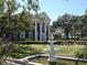 Stately red brick home with white columns and a charming fountain in the meticulously landscaped front yard at 5002 S Shore Crest Cir, Tampa, FL 33609
