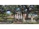 Elegant brick home behind a stone wall and iron gate, shaded by a mature oak tree at 5002 S Shore Crest Cir, Tampa, FL 33609