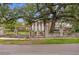 Brick home behind wall with wrought iron fence and gate, large oak tree hangs over the front at 5002 S Shore Crest Cir, Tampa, FL 33609