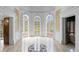 Grand foyer with marble floors, arched doorways, decorative wallpaper and large glass doors to exterior at 5002 S Shore Crest Cir, Tampa, FL 33609