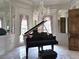 Music room featuring a grand piano, chandelier, and elegant window treatments at 5002 S Shore Crest Cir, Tampa, FL 33609