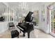 Music room showcasing a grand piano, crystal chandelier, and windows with elegant drapes at 5002 S Shore Crest Cir, Tampa, FL 33609