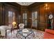 Office with dark wood paneling and multiple chairs around a floral carpet with a glass table at 5002 S Shore Crest Cir, Tampa, FL 33609