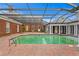 A large pool with a brick surround is enclosed by a glass and metal frame structure at 5002 S Shore Crest Cir, Tampa, FL 33609