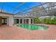 A large pool with a brick surround is enclosed by a glass and metal frame structure at 5002 S Shore Crest Cir, Tampa, FL 33609