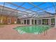 A large pool with a brick surround is enclosed by a glass and metal frame structure at 5002 S Shore Crest Cir, Tampa, FL 33609