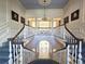 Elegant staircase with blue carpet, white railings, columns, and chandelier at 5002 S Shore Crest Cir, Tampa, FL 33609