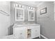 Bathroom vanity with dual sinks, granite countertop, white cabinetry, and decorative mirrors at 5080 43Rd S St, St Petersburg, FL 33711