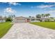 Inviting home exterior featuring a paver driveway, an attached garage, and a well-maintained front lawn at 5080 43Rd S St, St Petersburg, FL 33711