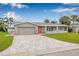 Charming single-story home with a well-manicured lawn, brick driveway, and attached two-car garage at 5080 43Rd S St, St Petersburg, FL 33711