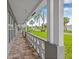 Covered front porch with concrete columns, brick flooring, and decorative concrete railings at 5080 43Rd S St, St Petersburg, FL 33711