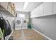 Spacious laundry room with washer, dryer, tile flooring, overhead lighting, and storage at 5080 43Rd S St, St Petersburg, FL 33711
