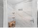 Bathroom shower featuring a wooden bench, marble tiles, built-in shelving, and glass door at 5080 43Rd S St, St Petersburg, FL 33711