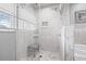 Bathroom shower featuring floor-to-ceiling marbled tiles, built-in shelving, and glass door at 5080 43Rd S St, St Petersburg, FL 33711
