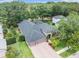 An aerial shot of the home with mature trees, a well-manicured lawn, and a screened-in pool at 5101 Hartwell Loop, Land O Lakes, FL 34638