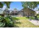 Well-maintained backyard with a screened pool enclosure, manicured lawn, and a seating area at 5101 Hartwell Loop, Land O Lakes, FL 34638