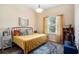 Bedroom with a patterned rug, bright window, and decorative pillows on the neatly made bed at 5101 Hartwell Loop, Land O Lakes, FL 34638