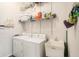 Functional laundry room featuring modern washer, dryer, utility sink, and ample storage shelves at 5101 Hartwell Loop, Land O Lakes, FL 34638