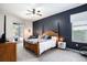 Spacious main bedroom with en-suite bath, dark accent wall and sliding doors to backyard at 5101 Hartwell Loop, Land O Lakes, FL 34638