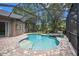 Beautiful kidney-shaped pool and spa area surrounded by a screened-in lanai and brick pavers at 5101 Hartwell Loop, Land O Lakes, FL 34638