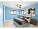 Blue bedroom with wood floors, a ceiling fan and large windows at 5108 Commonwealth Rd, Palmetto, FL 34221