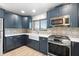 Modern kitchen featuring blue cabinets, stainless steel appliances, and patterned backsplash at 5108 Commonwealth Rd, Palmetto, FL 34221