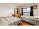 Bedroom with hardwood floors, twin beds, and a window with blue curtains at 5623 80Th N St # 504, St Petersburg, FL 33709