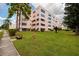 Well maintained building exterior with green lawn and landscaping, bench and fire hydrant in view at 5623 80Th N St # 504, St Petersburg, FL 33709