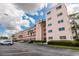Spacious condo building with parking, palm trees, and manicured landscaping at 5623 80Th N St # 504, St Petersburg, FL 33709