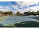 Well-maintained outdoor tennis court with nets in place and trees surrounding the court at 5623 80Th N St # 504, St Petersburg, FL 33709