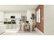 Contemporary open-concept dining room adjacent to a modern kitchen with white cabinets and stainless appliances at 5627 Red Kite Dr, Wimauma, FL 33598