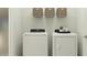 Functional laundry room with a white washer and dryer set and storage options on the wire shelf at 5627 Red Kite Dr, Wimauma, FL 33598