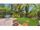 Inviting backyard patio with brick pavers, lush tropical foliage, a fire pit, and outdoor seating at 5835 29Th N Ave, St Petersburg, FL 33710