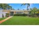 Well-kept single story home featuring a lush green lawn and mature landscaping enhancing the property's curb appeal at 5835 29Th N Ave, St Petersburg, FL 33710