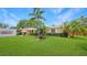 Charming single-story home featuring lush green lawn and mature palm trees in a sunny setting at 5835 29Th N Ave, St Petersburg, FL 33710