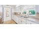 Well-lit kitchen featuring white cabinetry, stainless sink, and views into other living areas at 5835 29Th N Ave, St Petersburg, FL 33710