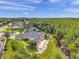 Aerial view of a home with a screened-in pool, patio, and manicured lawn overlooking a natural stream at 6212 Nimes Ct, Lutz, FL 33558