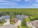 Aerial view of a luxurious home with a circular driveway and beautifully landscaped yard backed by a forest at 6212 Nimes Ct, Lutz, FL 33558