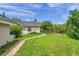 Expansive backyard featuring lush green grass, mature trees, and a charming brick walkway at 6212 Nimes Ct, Lutz, FL 33558