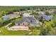 Aerial view of a home with a screened-in pool, a stone patio, and meticulous landscaping at 6212 Nimes Ct, Lutz, FL 33558