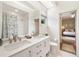 Bright white bathroom featuring double sinks, tiled floors, and shower with curtain at 6212 Nimes Ct, Lutz, FL 33558