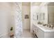 Bright white bathroom featuring tub with shower, tiled floors, and double sink vanity at 6212 Nimes Ct, Lutz, FL 33558