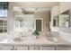 Double-sink bathroom vanity with a large mirror reflecting the modern tiled finishes and natural lighting at 6212 Nimes Ct, Lutz, FL 33558