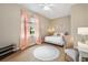 Serene bedroom featuring a window, sheer curtains, neutral colors, and wood floors at 6212 Nimes Ct, Lutz, FL 33558