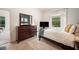 Well-lit bedroom with a large dresser, TV, and views of nature through the window at 6212 Nimes Ct, Lutz, FL 33558